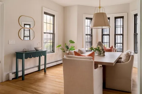 a living room with furniture a chandelier and a window