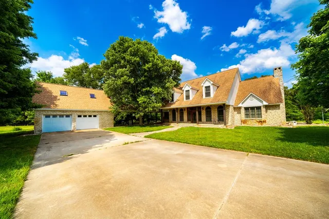 a view of a house with a yard and tree s