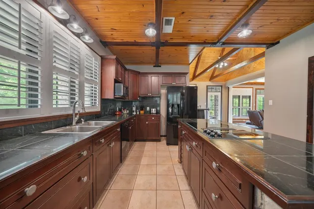 a large kitchen with stainless steel appliances granite countertop a sink and counter space
