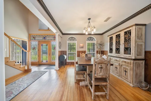 a view of a dining room with furniture a chandelier and wooden floor