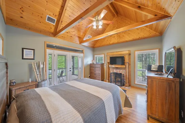 a bedroom with a bed next to a large window with the view of living room