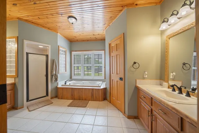 a bathroom with a tub sink and mirror