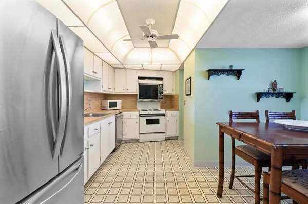 a kitchen with stainless steel appliances a stove a refrigerator and a chandelier