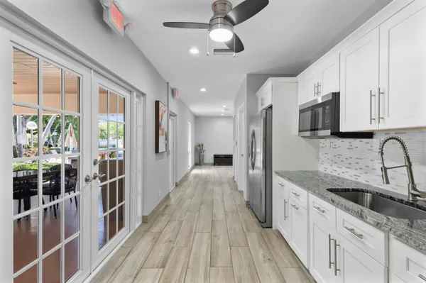 a view of a kitchen with stainless steel appliances granite countertop a stove and a sink