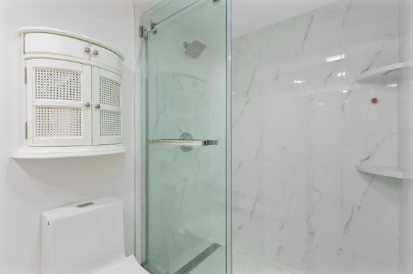 a bathroom with a shower and a glass door