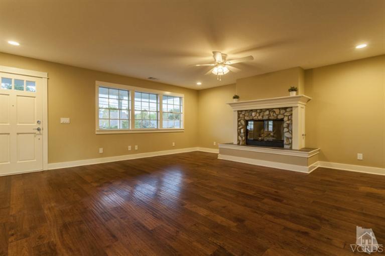 25029 Wheeler Road Newhall, CA 91321 - Photo 6 of 33 an empty room with wooden floor fireplace and windows