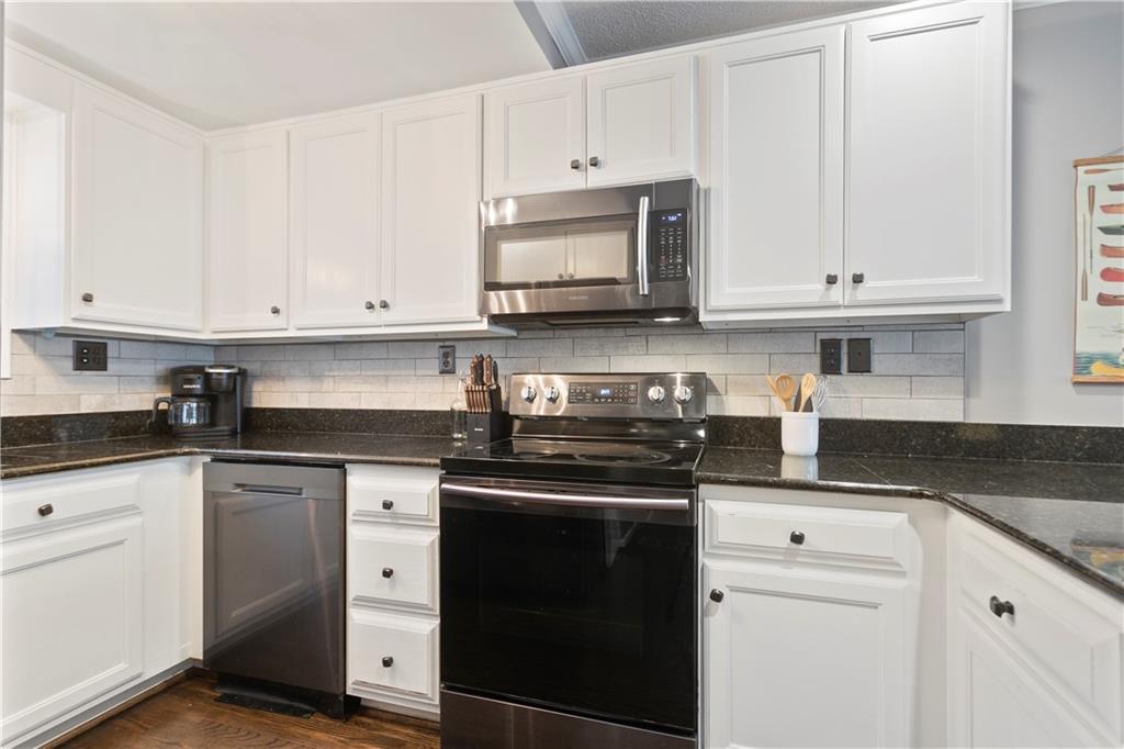 641 Riverside Drive Ellijay, GA 30540 - Photo 14 of 42 a kitchen with granite countertop white cabinets and a stove a oven with white countertops