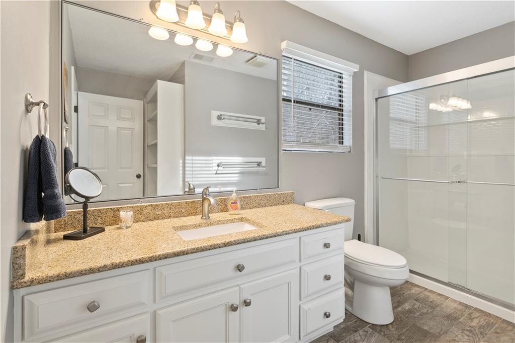 641 Riverside Drive Ellijay, GA 30540 - Photo 27 of 42 a bathroom with a granite countertop double vanity sink a mirror and a toilet