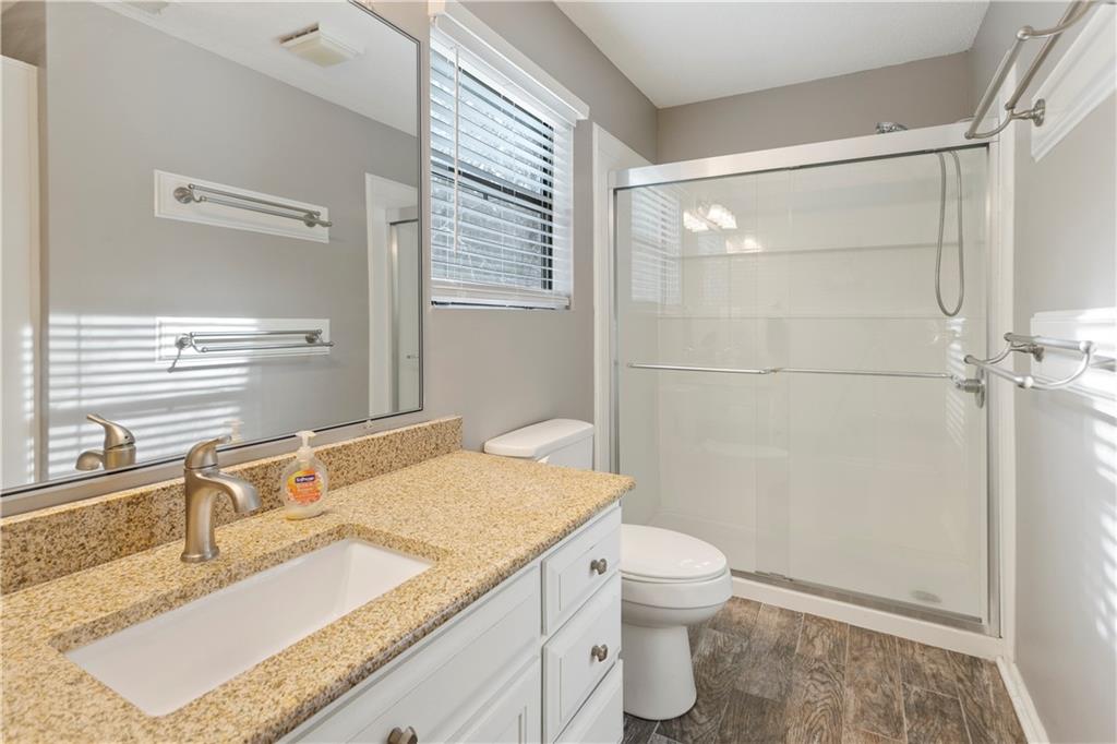641 Riverside Drive Ellijay, GA 30540 - Photo 29 of 42 a bathroom with a granite countertop sink a toilet and shower