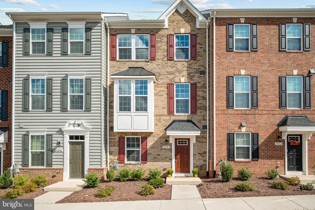 a front view of a house with a yard and glass windows