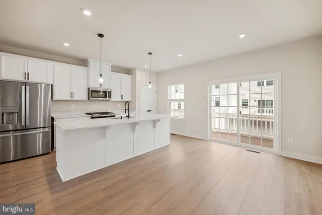 a kitchen with stainless steel appliances a refrigerator sink and wooden floor