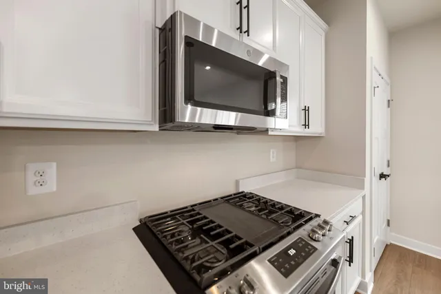 a stove top oven sitting inside of a kitchen