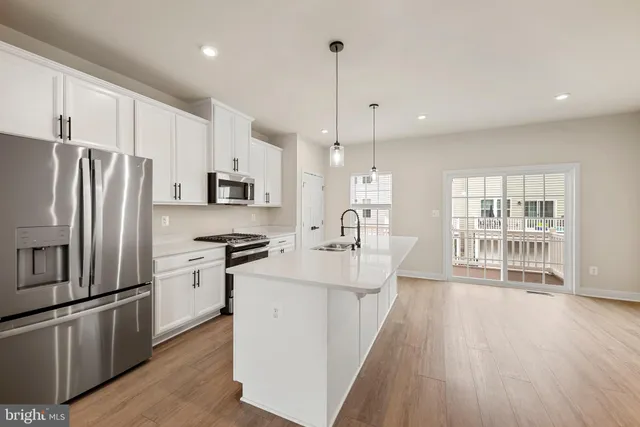 a kitchen with stainless steel appliances a refrigerator a stove a sink and a center island