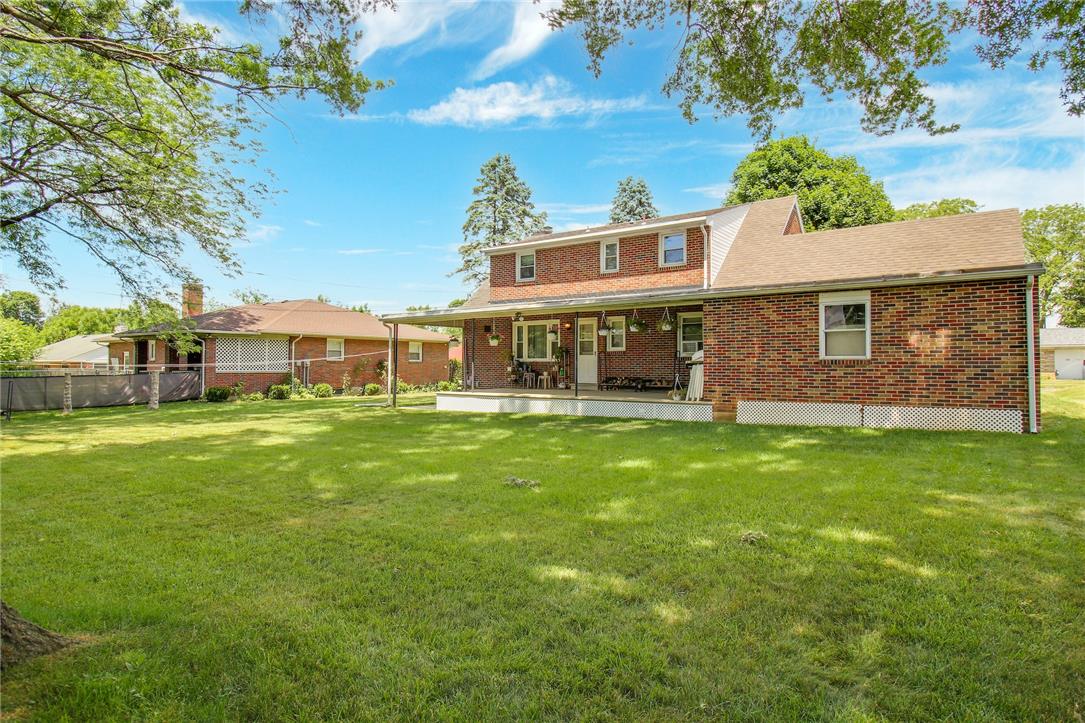 1256 Ridge Avenue Whitehall, PA 18052 - Photo 13 of 43 A spacious backyard with mature trees offers a private, verdant setting for this classic brick home featuring a charming covered patio.