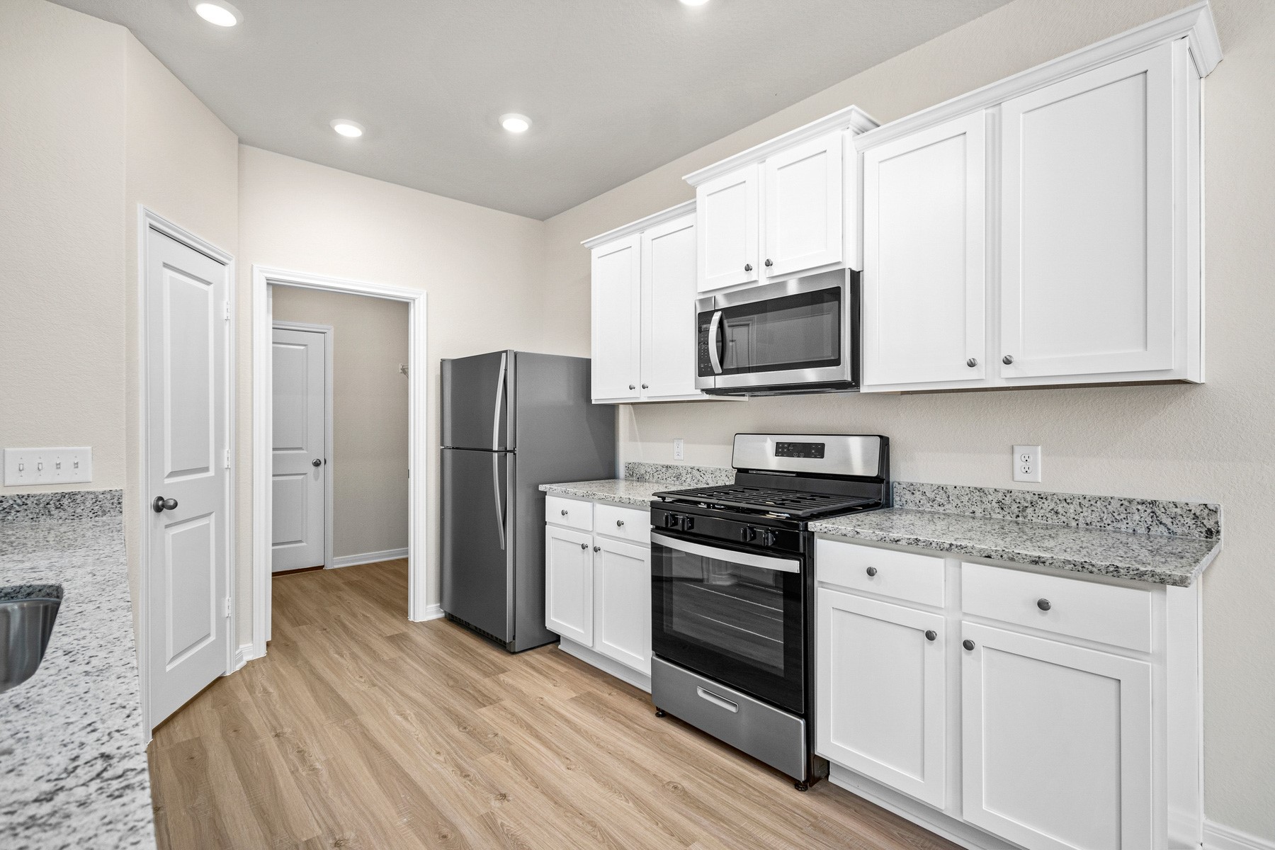 376 Fastboy Lane Waller, TX 77484 - Photo 4 of 22 a kitchen with stainless steel appliances granite countertop a stove a refrigerator and a microwave