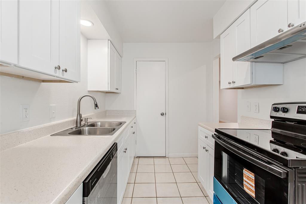 6061 Milton Street, Unit 231 Dallas, TX 75206 - Photo 9 of 27 Bright galley-style kitchen offering generous cabinet storage, updated finishes, and a clean modern aesthetic.