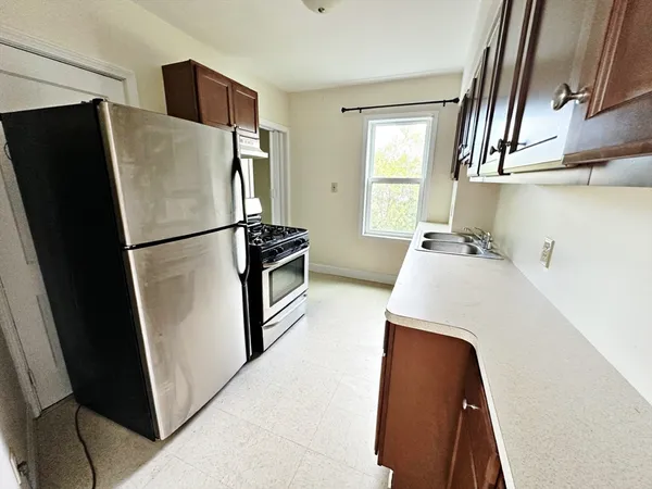 a kitchen with stainless steel appliances a refrigerator a sink a stove and cabinets