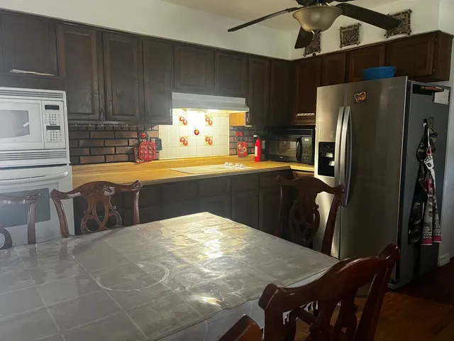 a kitchen with stainless steel appliances a refrigerator a sink a stove and island