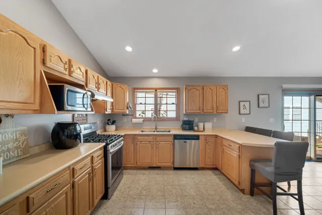 a kitchen with lots of appliances a sink a counter top space cabinets and a window