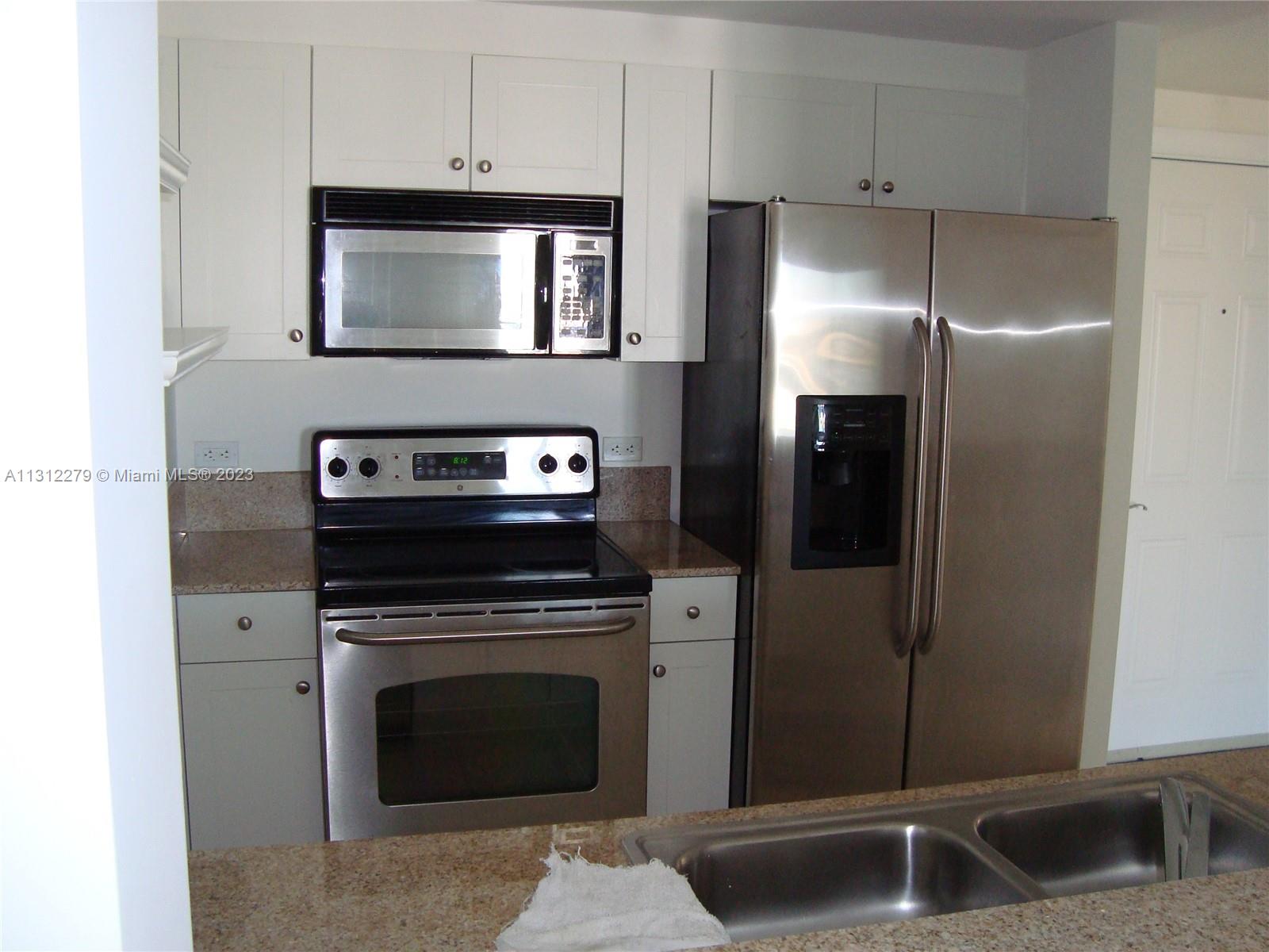117 Northwest 42nd Avenue, Unit 1609 Miami, FL 33126 - Photo 7 of 15 a kitchen with cabinets and stainless steel appliances