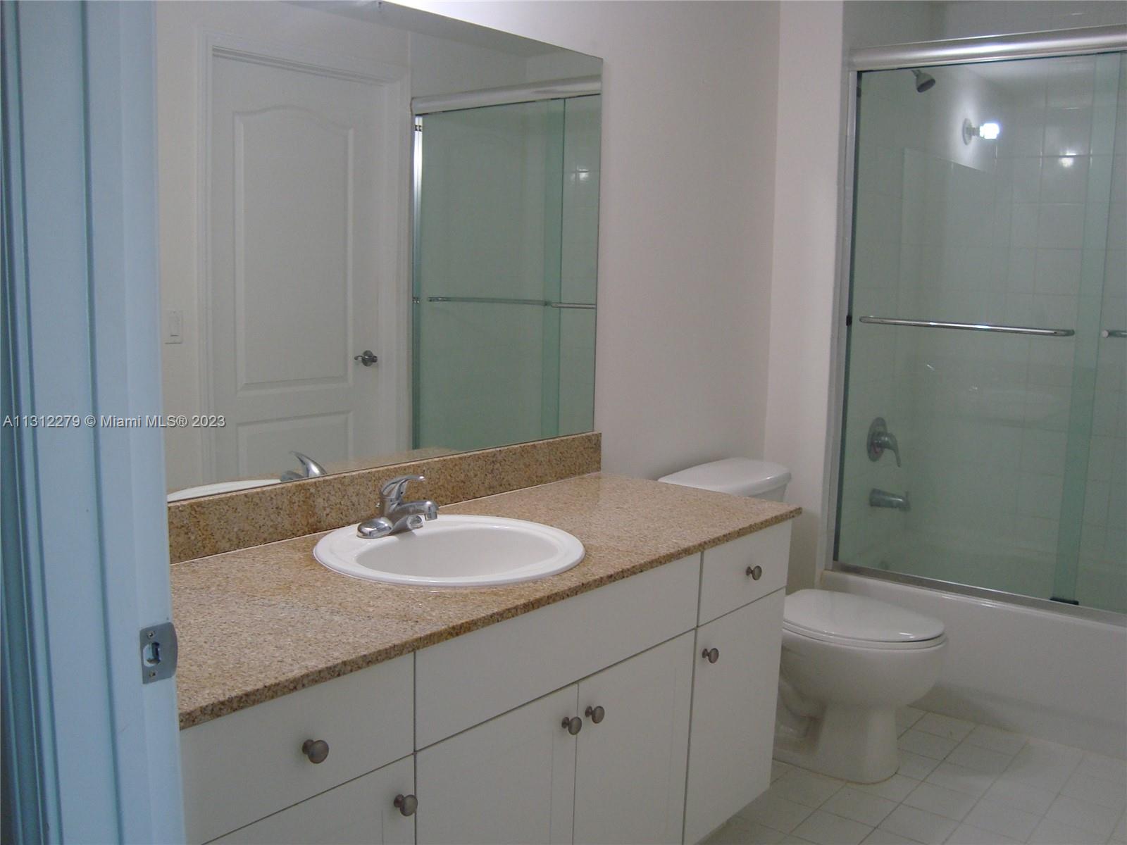 117 Northwest 42nd Avenue, Unit 1609 Miami, FL 33126 - Photo 10 of 15 a bathroom with a granite countertop sink toilet and shower