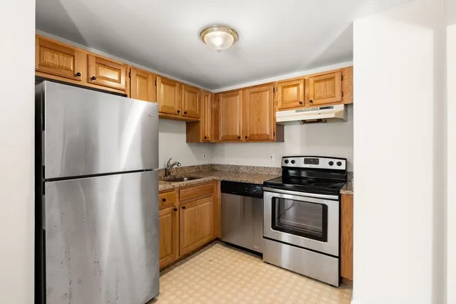 a white refrigerator freezer and a stove sitting inside of a kitchen