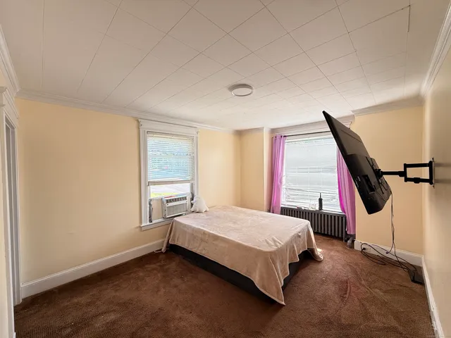 a bedroom with a bed next to a window