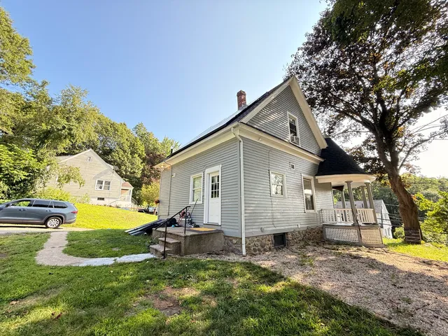 a view of a house with a yard and sitting area