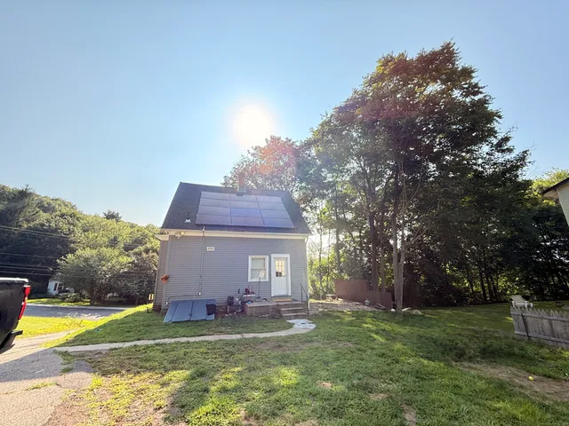 a view of a house with garden and trees