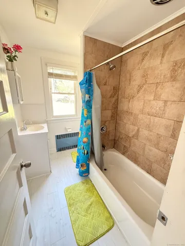 a bathroom with a bath tub a sink and a shower