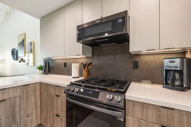 a living room with lots of furniture and view of kitchen