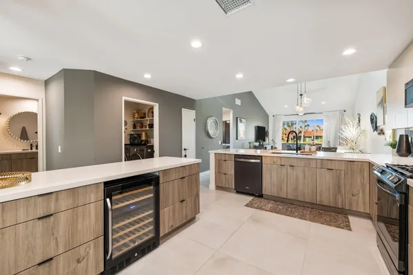 a living room with lots of furniture and view of kitchen