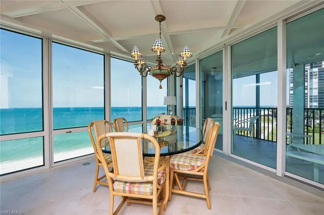 a dining room with furniture chandelier and glass door