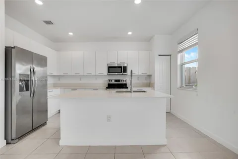 a kitchen with stainless steel appliances granite countertop a refrigerator and a stove