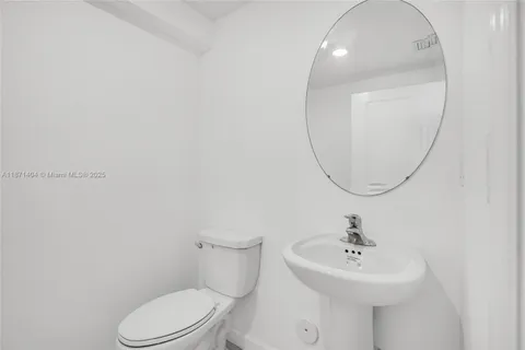 a bathroom with a sink a mirror and toilet