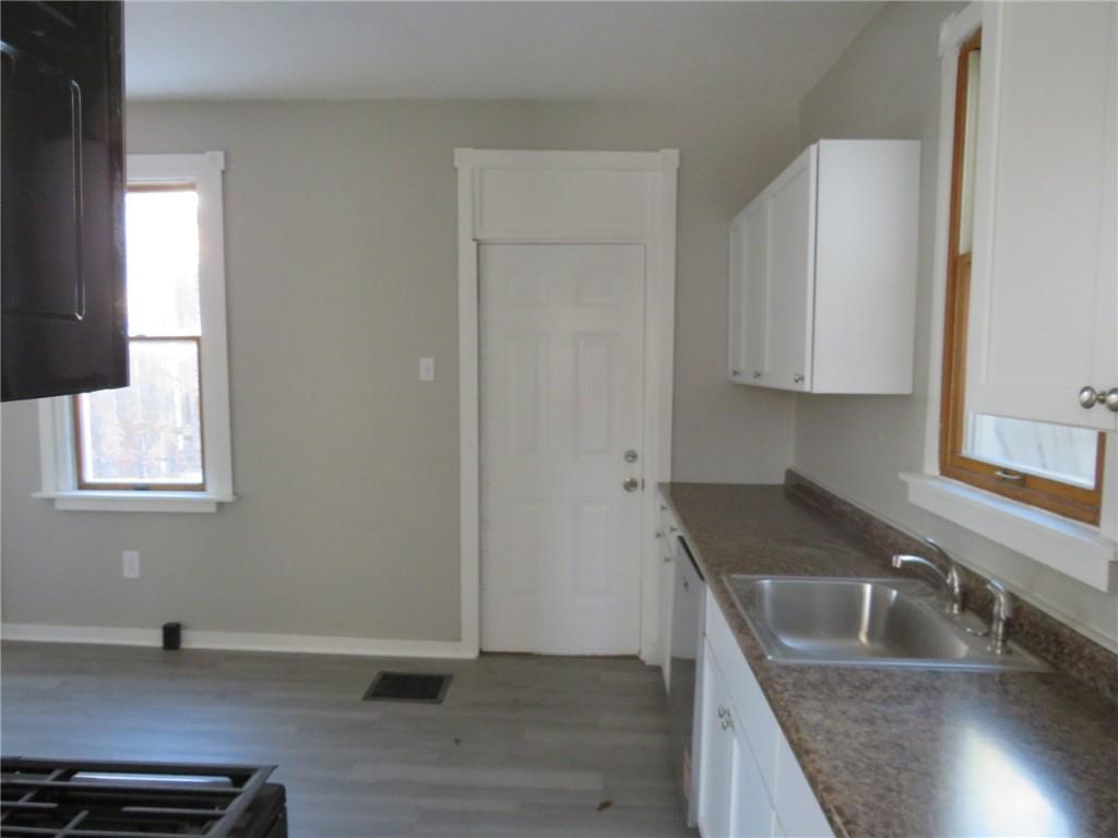 301 Paur Street Pittsburgh, PA 15211 - Photo 16 of 19 a kitchen with granite countertop a sink a stove and cabinets