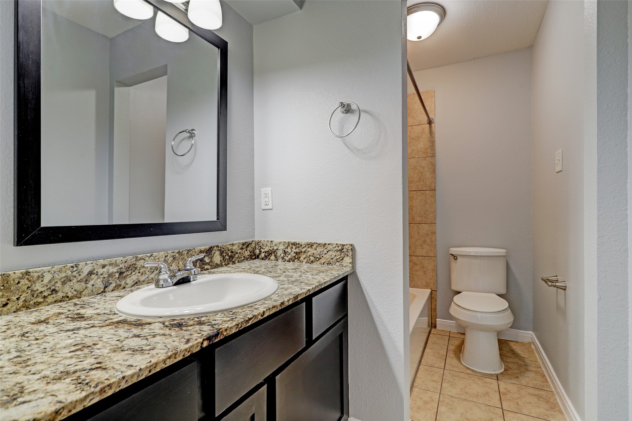 1600 West T C Jester Boulevard, Unit 1 Houston, TX 77008 - Photo 8 of 9 a bathroom with a granite countertop sink a toilet and a mirror