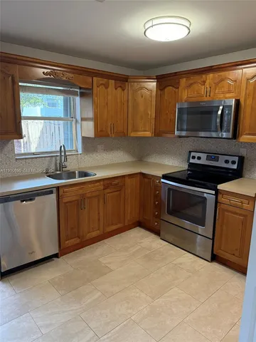a kitchen with stainless steel appliances granite countertop a sink stove and microwave