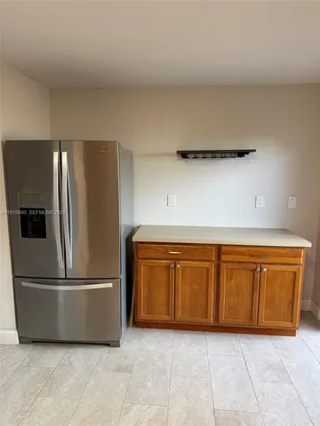 a kitchen with granite countertop a refrigerator and a sink
