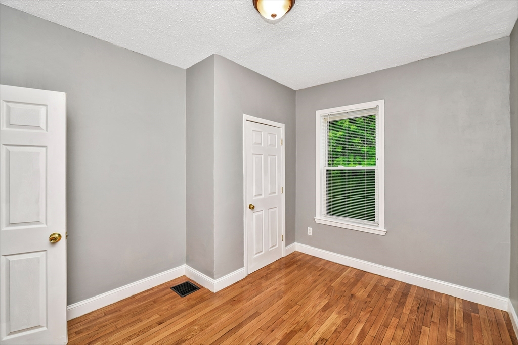 352 Norfolk Street, Unit 3 Boston, MA 02124 - Photo 10 of 12 an empty room with wooden floor and windows