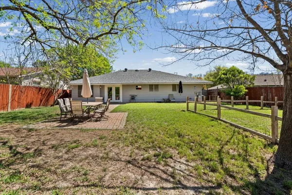 a view of a house with backyard and a tree