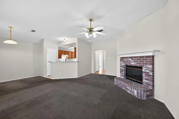 a view of a livingroom with a fireplace and a chandelier fan