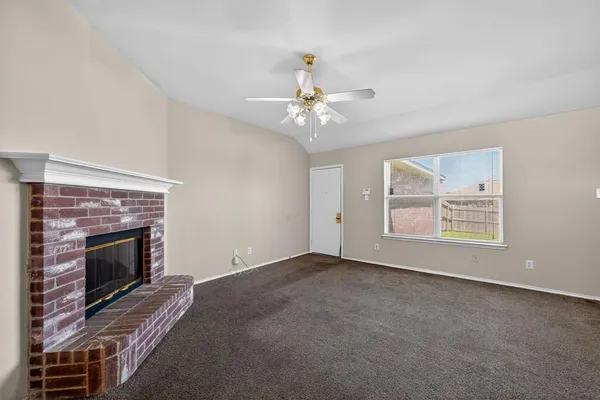 a view of empty room with fireplace and fan