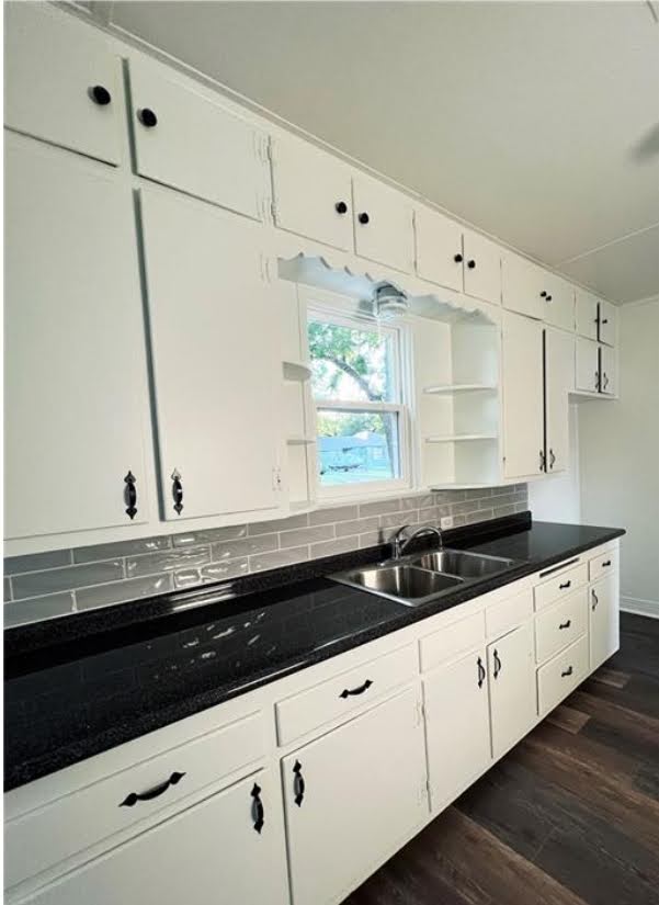 809 North 8th Street Temple, TX 76501 - Photo 4 of 20 A well-lit kitchen features white cabinetry, dark countertops, and a subway tile backsplash.