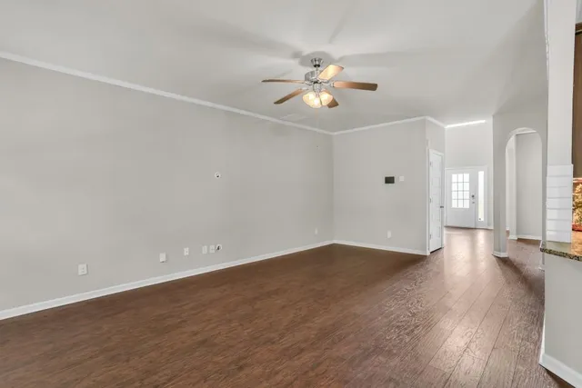 a view of a big room with wooden floor and windows