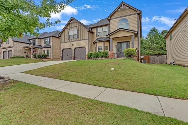 a front view of a house with a yard and garage