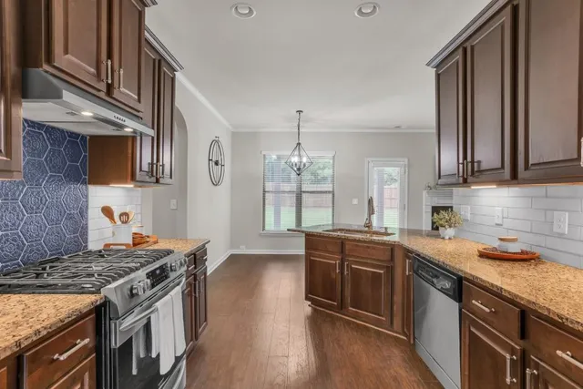 a kitchen with stainless steel appliances granite countertop a stove and a sink