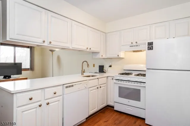 a kitchen with cabinets appliances a sink and a window
