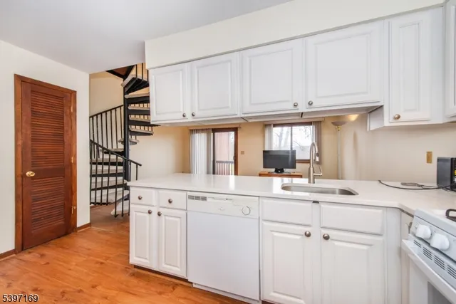 a kitchen with white cabinets and sink