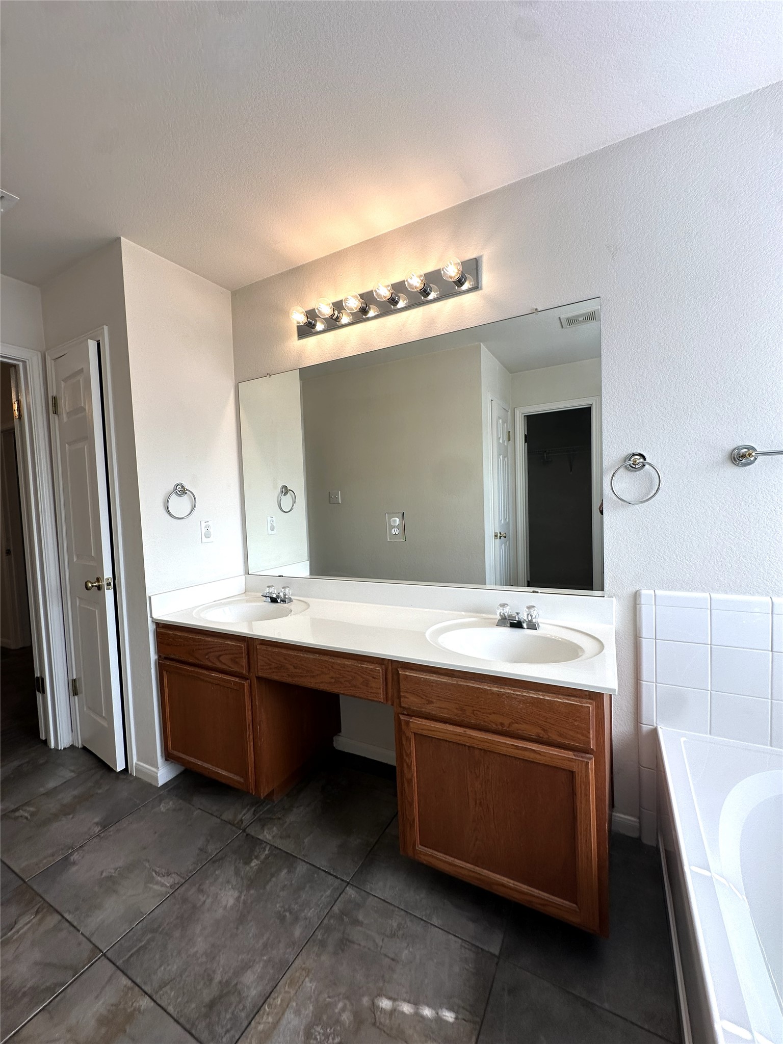 722 Ranier Lane Round Rock, TX 78665 - Photo 11 of 24 A spacious double vanity and tiled flooring anchor this functional primary bathroom layout.